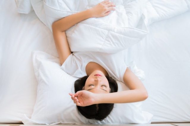 Asian girl is headache in bed.top view