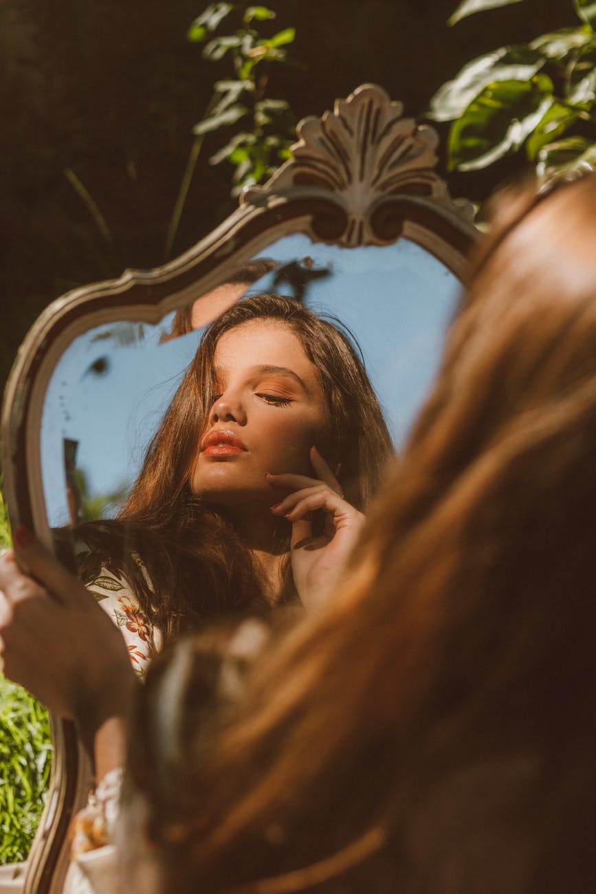 woman reflecting in mirror in nature