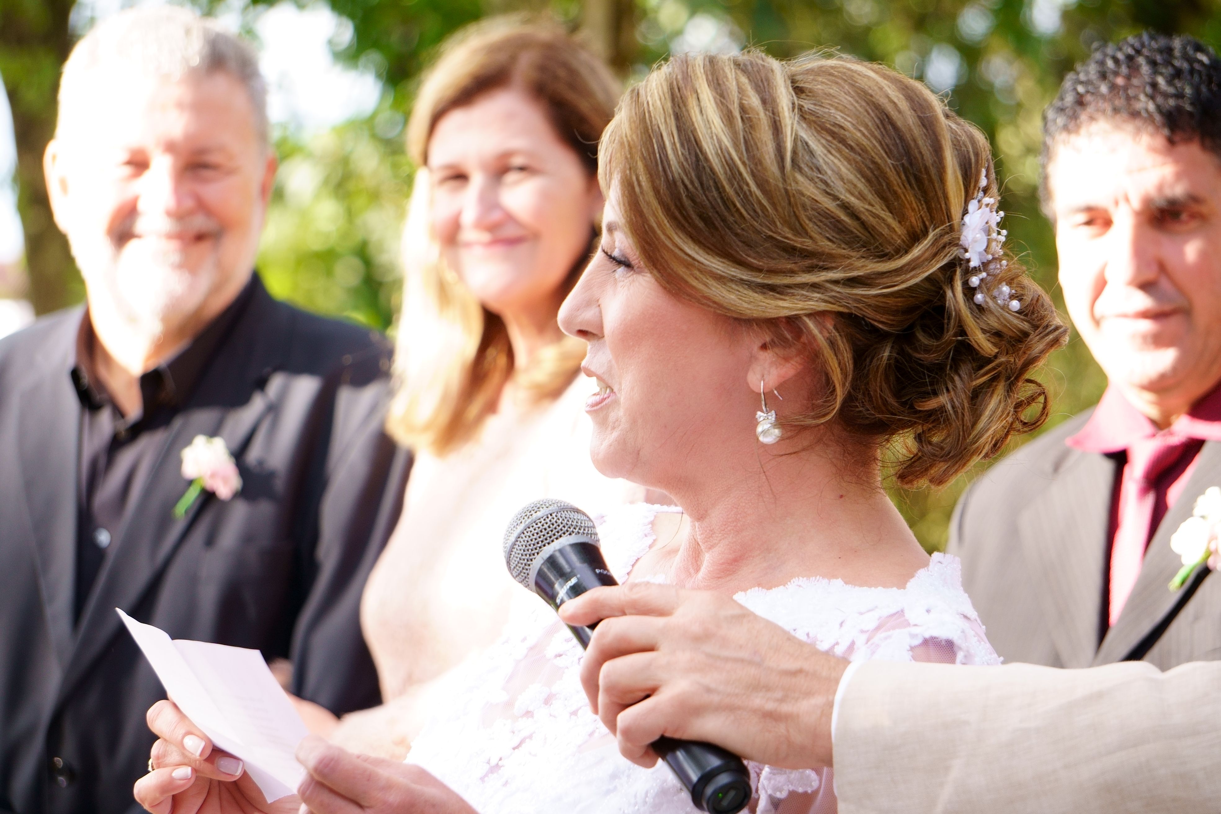 A woman delivering a heartfelt, genuine wedding speech at an outdoor ceremony