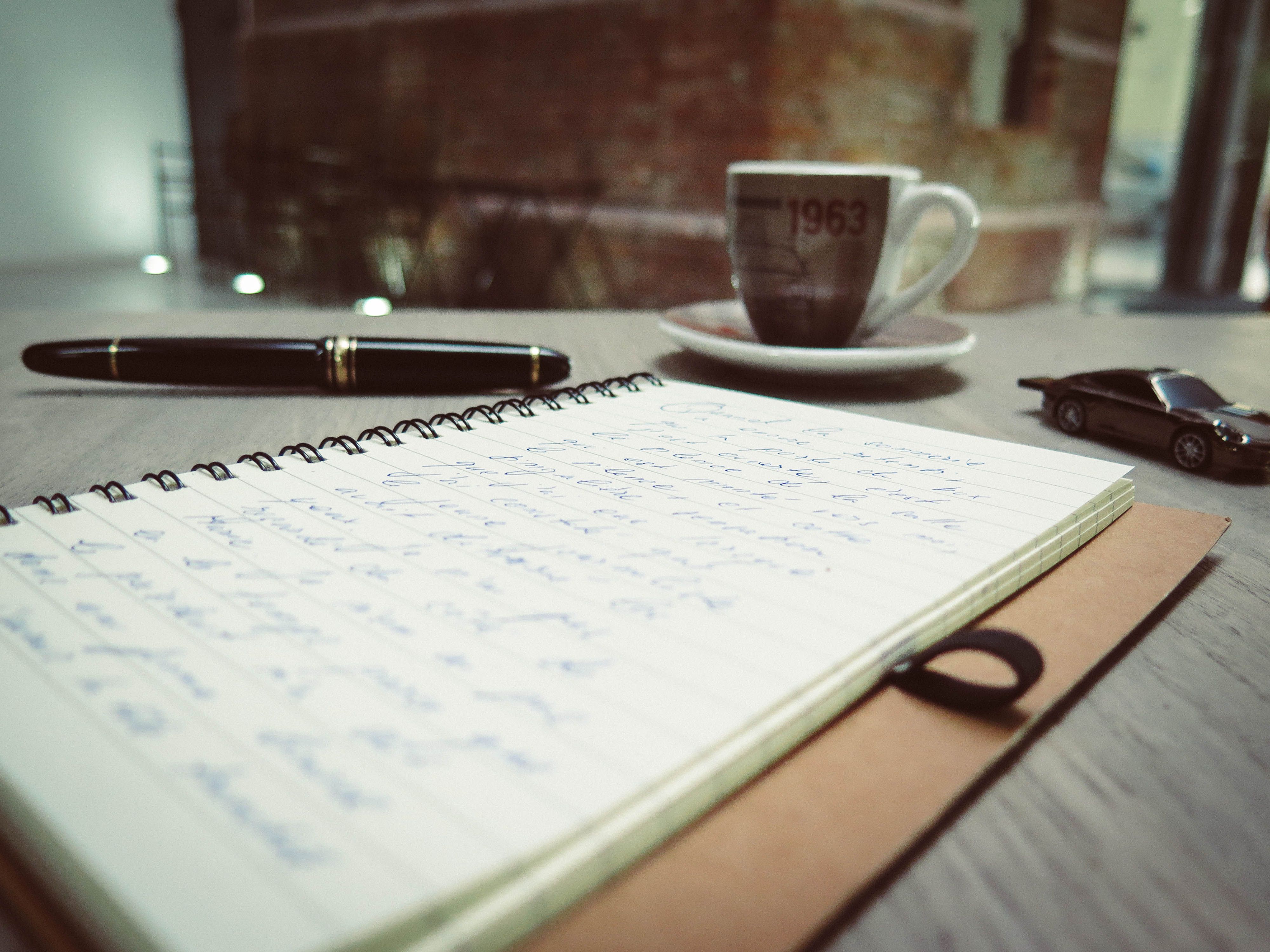 Handwritten notes and a pen on a desk for drafting a last-minute wedding toast